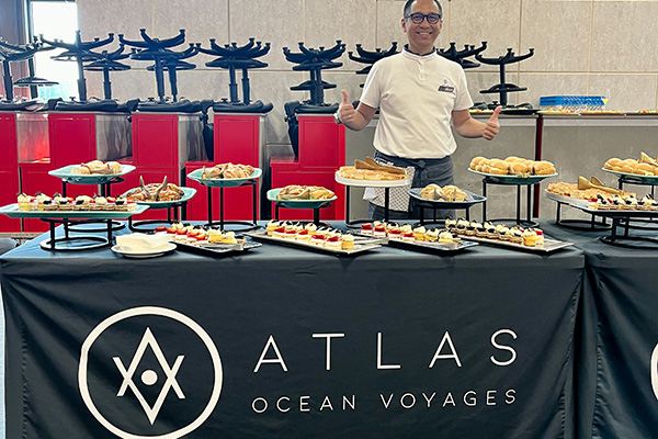 Atlas Ocean Voyages' World Traveller Crew serving canapes and serving drinks before checking in and boarding the ship
