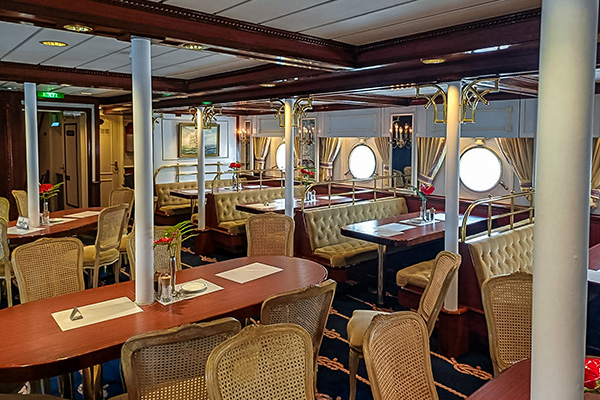 Dining room on Star Flyer has portholes are six-seat booths, while circular and oval tables fill the restaurant's centre. The dining room exudes elegance, with royal blue carpets adorned with gold rope designs.